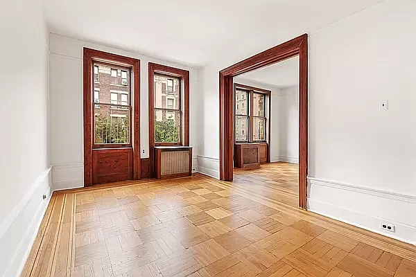 a view of an empty room with window and bathroom