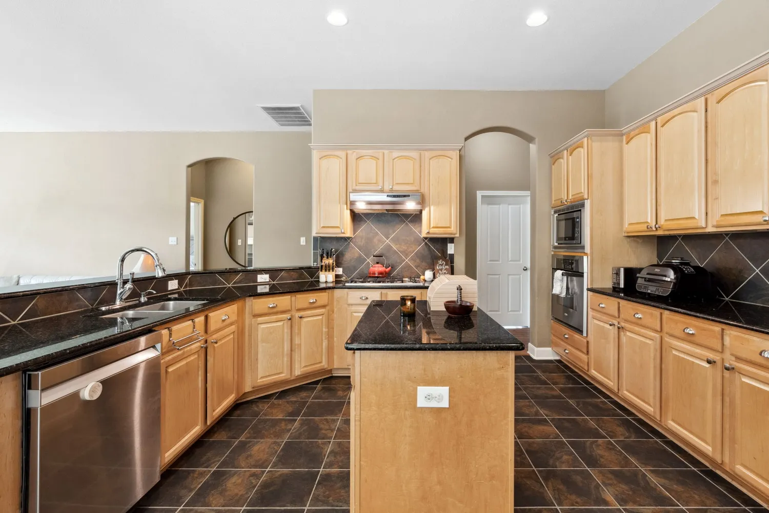 a kitchen with granite countertop a stove a sink dishwasher and a granite counter top
