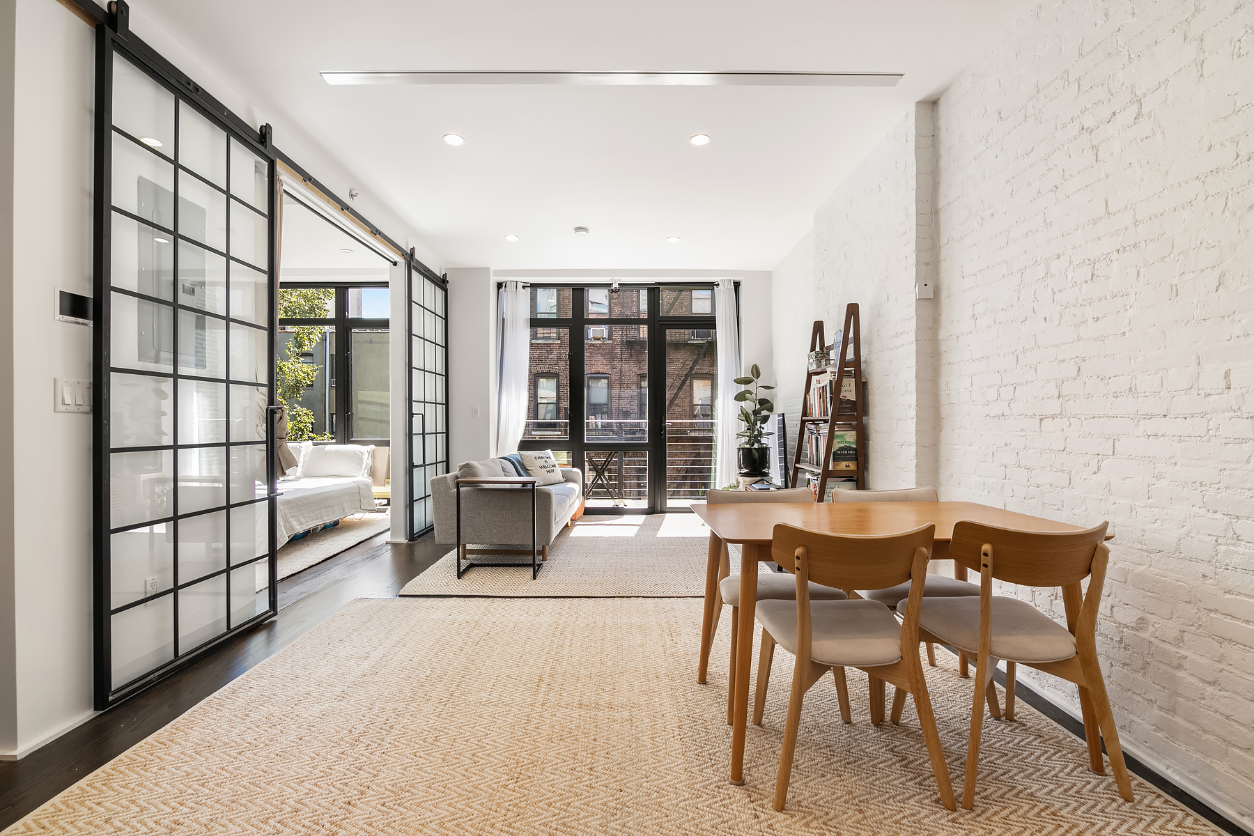 a dining room with furniture and large windows