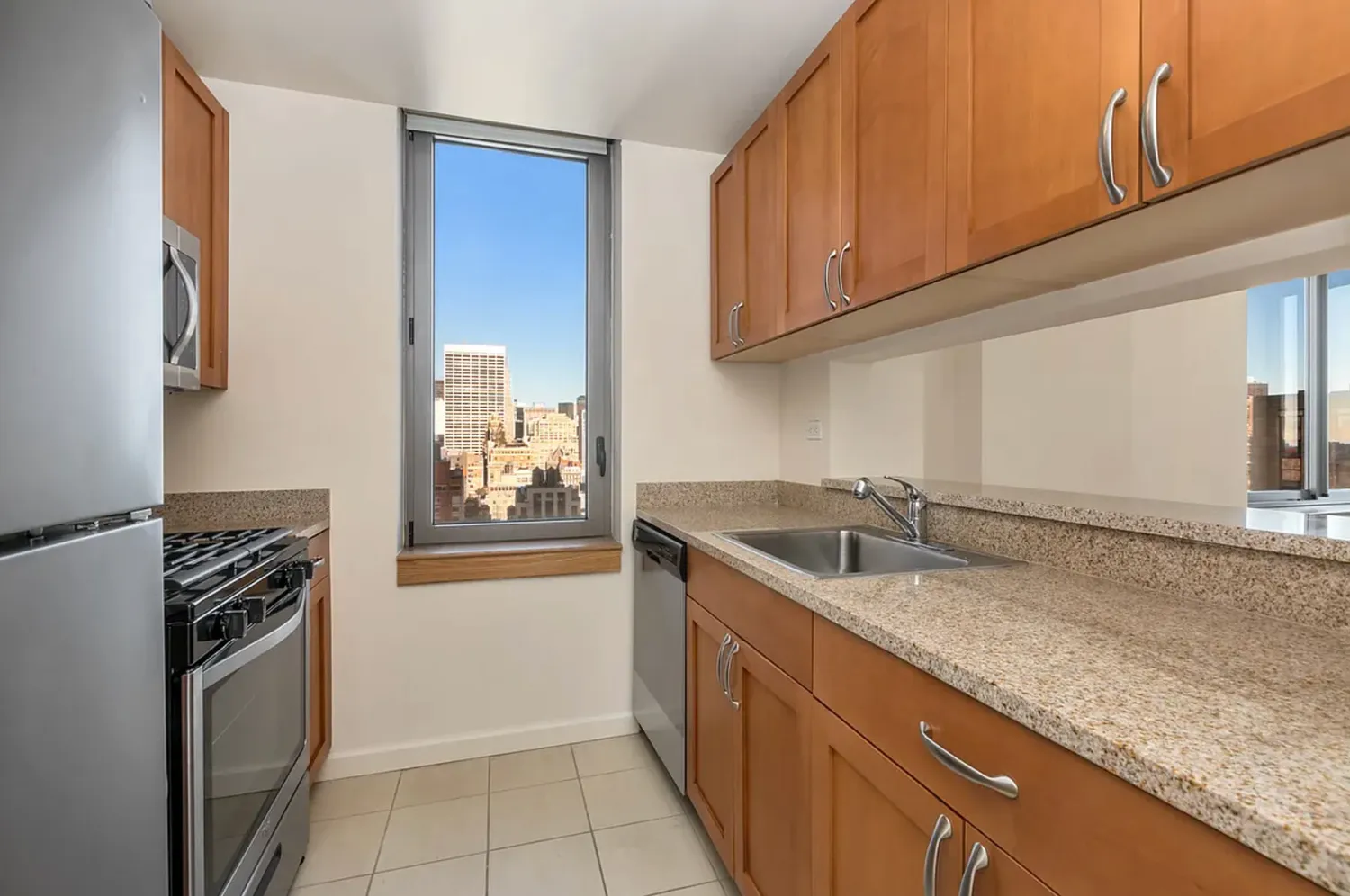 a kitchen with granite countertop a sink a stove and cabinets