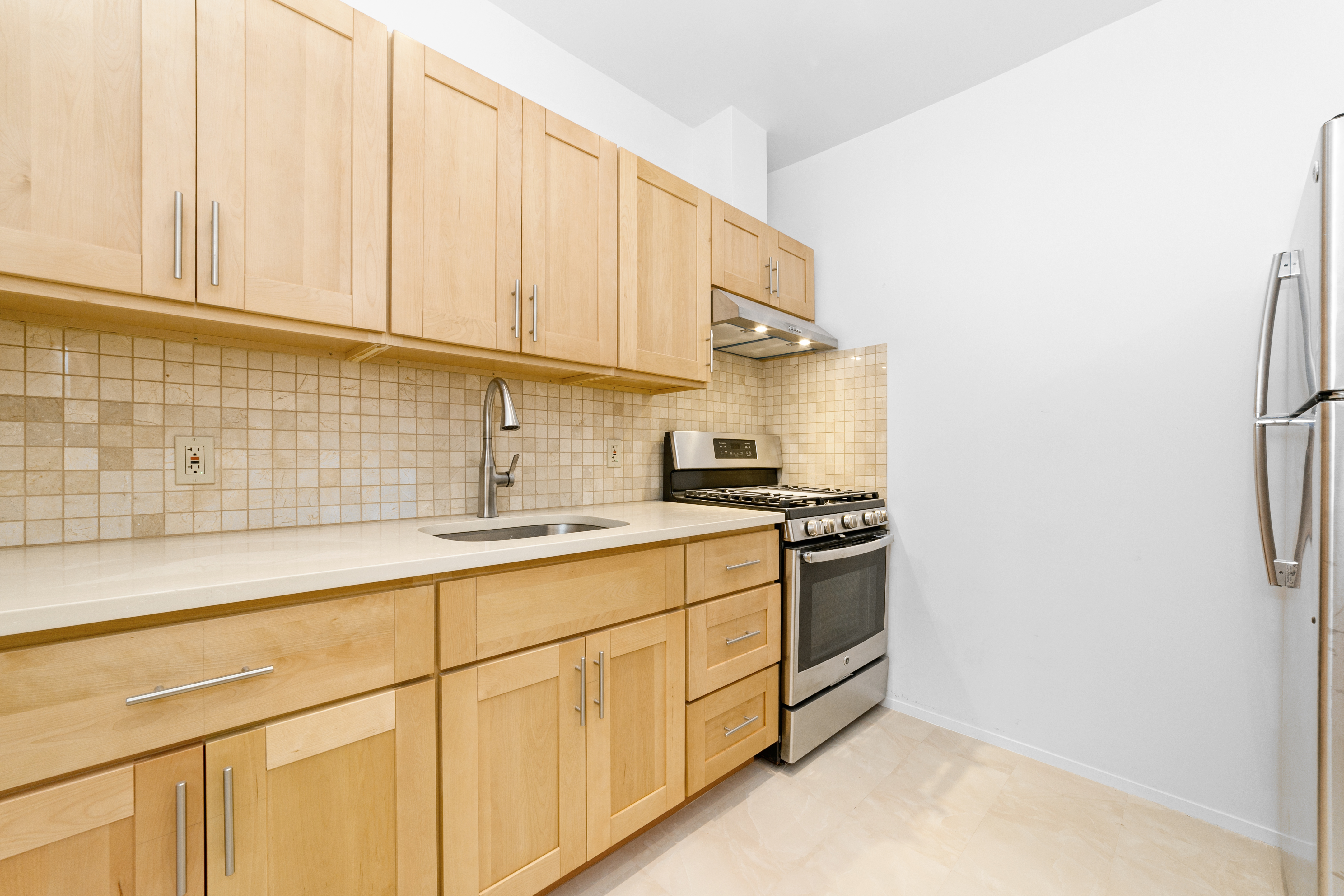 24-41 82nd Street Queens, NY 11370 - Photo 5 of 15 a kitchen with stainless steel appliances white cabinets and a sink