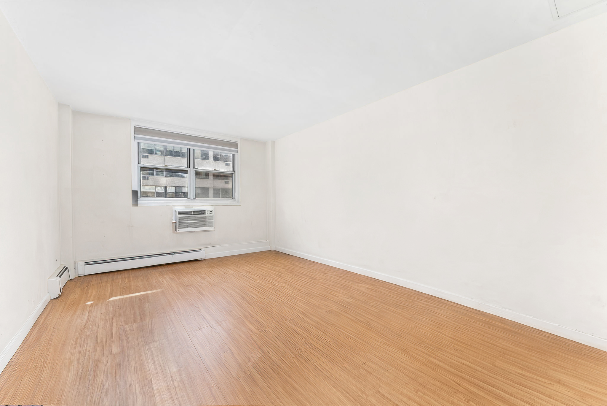 40 Sutton Place, Unit 9J Manhattan, NY 10022 - Photo 8 of 11 an empty room with windows