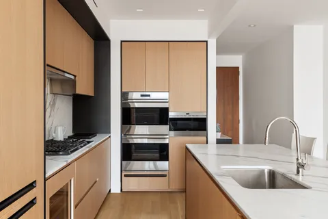 a kitchen with kitchen island stainless steel appliances a sink stove and refrigerator