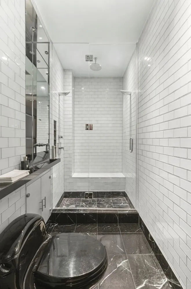 a bathroom with a sink a toilet a mirror and shower