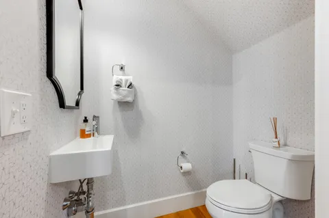 a bathroom with a toilet a sink and mirror