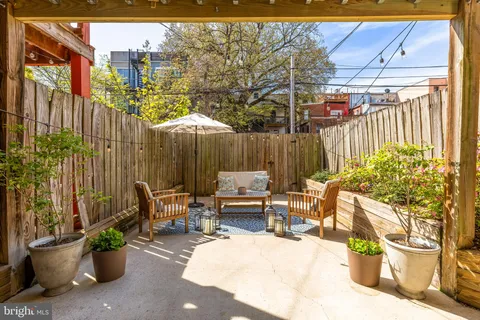 a view of a patio with a table and chairs and potted plants