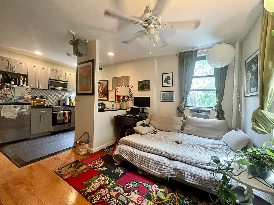 210 Thompson Street, Unit 4DN Manhattan, NY 10012 - Photo 2 of 10 a living room with furniture fireplace and a large window