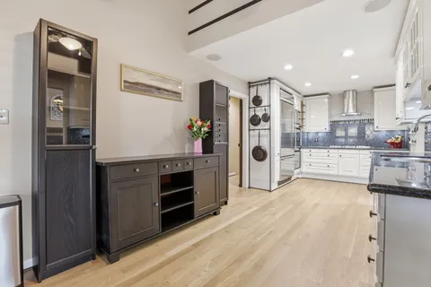 a kitchen with stainless steel appliances granite countertop a sink a stove and cabinets