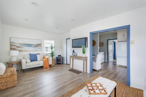 a living room with furniture and a wooden floor