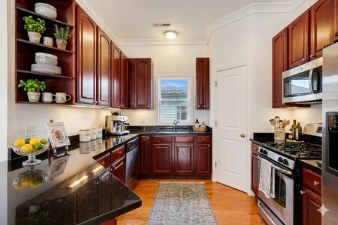 a kitchen with stainless steel appliances granite countertop a stove sink and cabinets