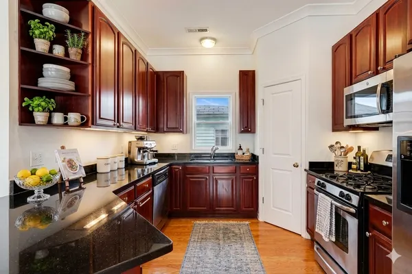 a kitchen with stainless steel appliances granite countertop a stove sink and cabinets