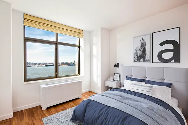 100 Morton Street, Unit 14CW Manhattan, NY 10014 - Photo 5 of 8 a bedroom with a bed and a large window with wooden floor