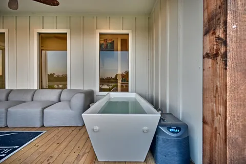 a patio with wooden floor a yard tables and chairs