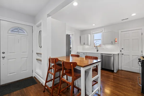 a kitchen with stainless steel appliances granite countertop a white cabinets and wooden floor