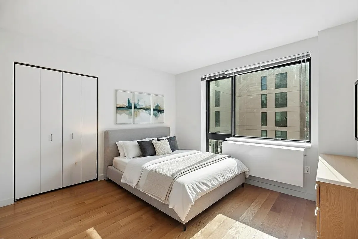 44-72 11th Street, Unit B302 Queens, NY 11101 - Photo 3 of 12 a bedroom with a large bed and a large window