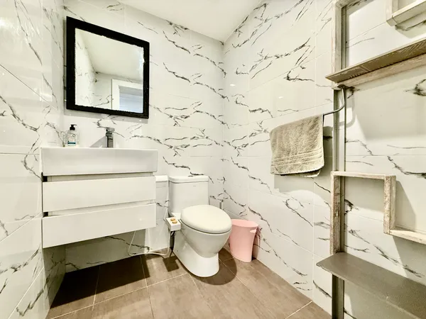 a bathroom with a sink toilet and a mirror