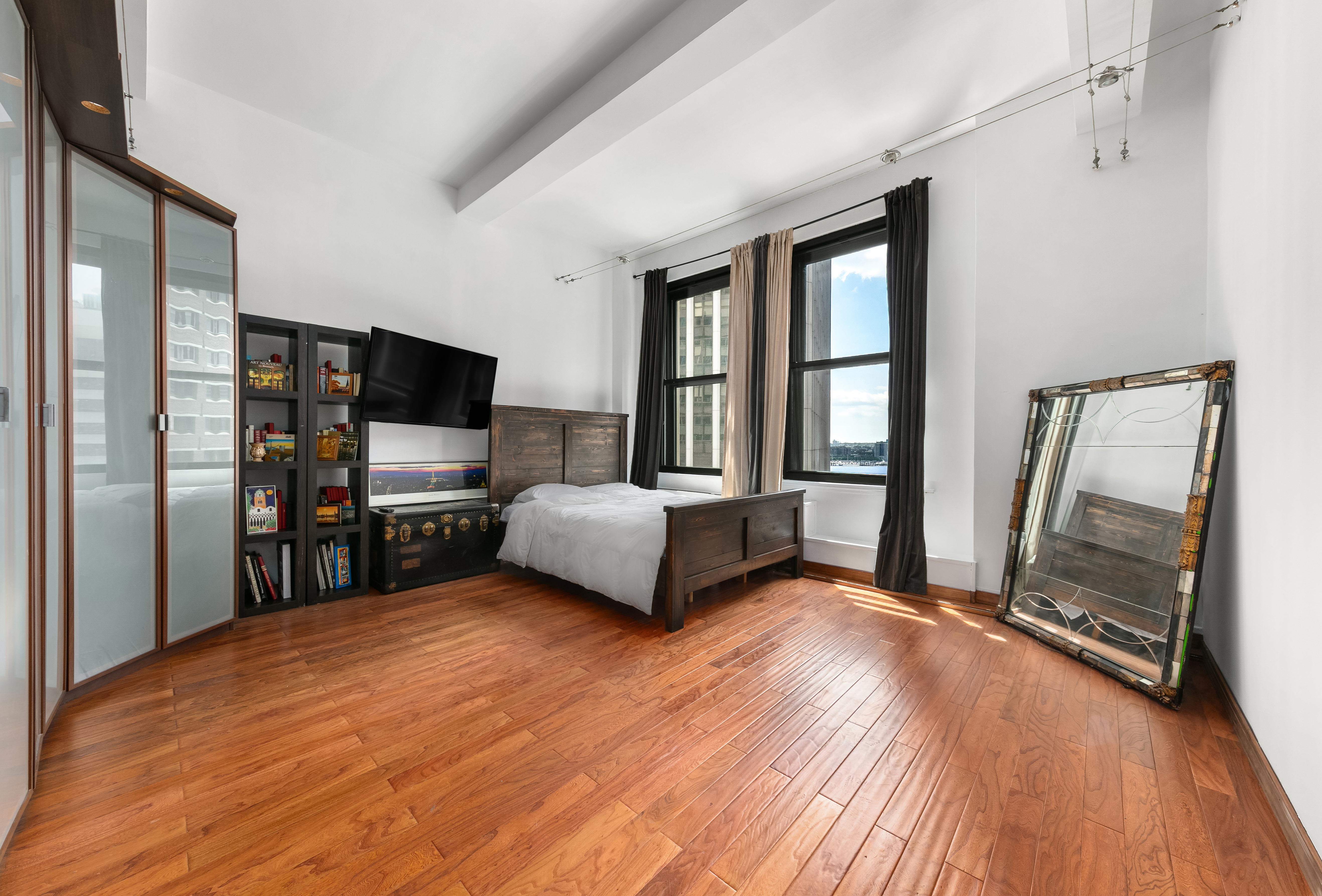 a room with a bed furniture and a flat tv screen