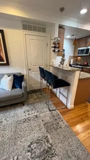 a living room with furniture and a wooden floor