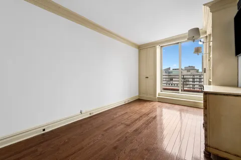 an empty room with wooden floor and window