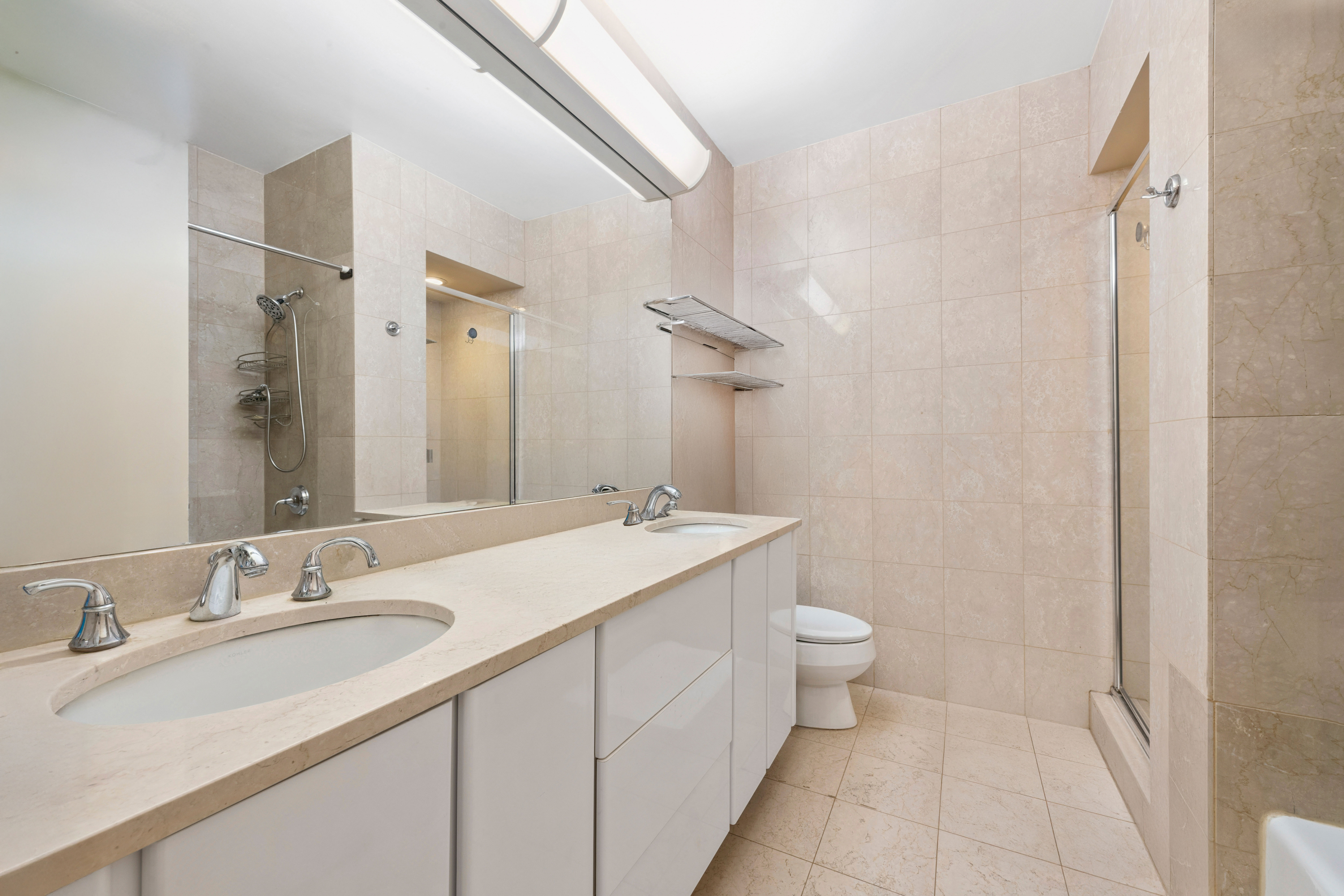 200 East 69th Street, Unit 4N Manhattan, NY 10021 - Photo 5 of 13 a bathroom with a sink double vanity and a toilet