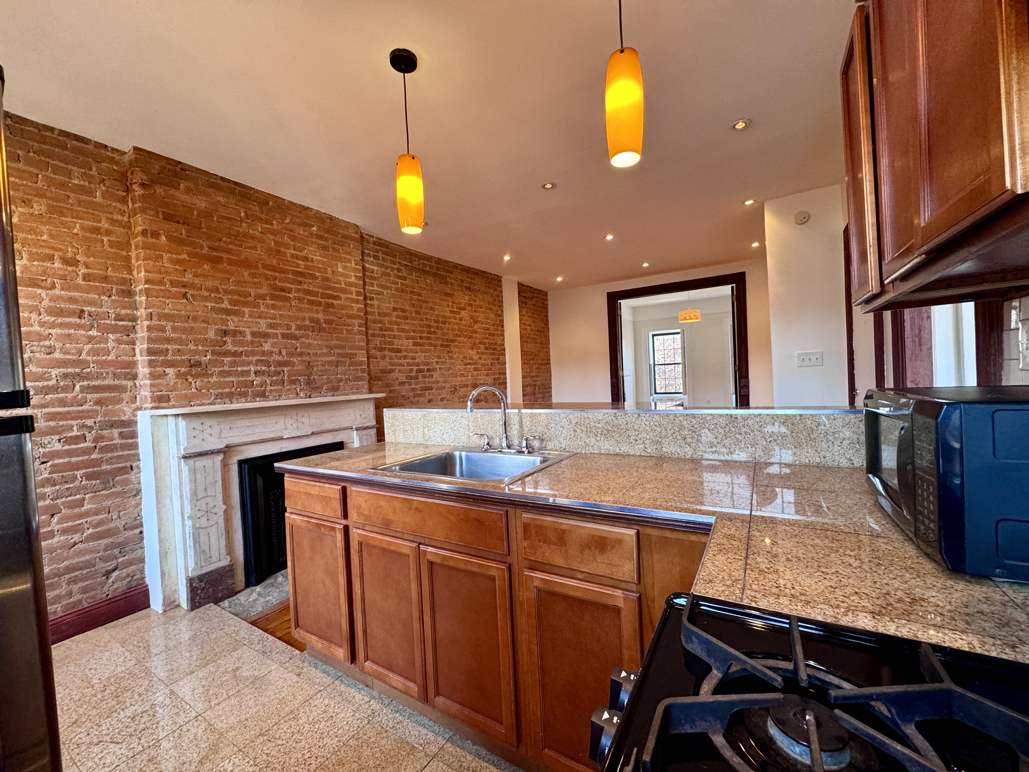 15 Arlington Place, Unit 3 Brooklyn, NY 11216 - Photo 5 of 14 a kitchen with kitchen island granite countertop a stove a sink and a refrigerator