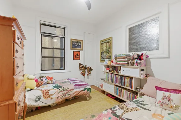 a bedroom with a bed and a book shelf