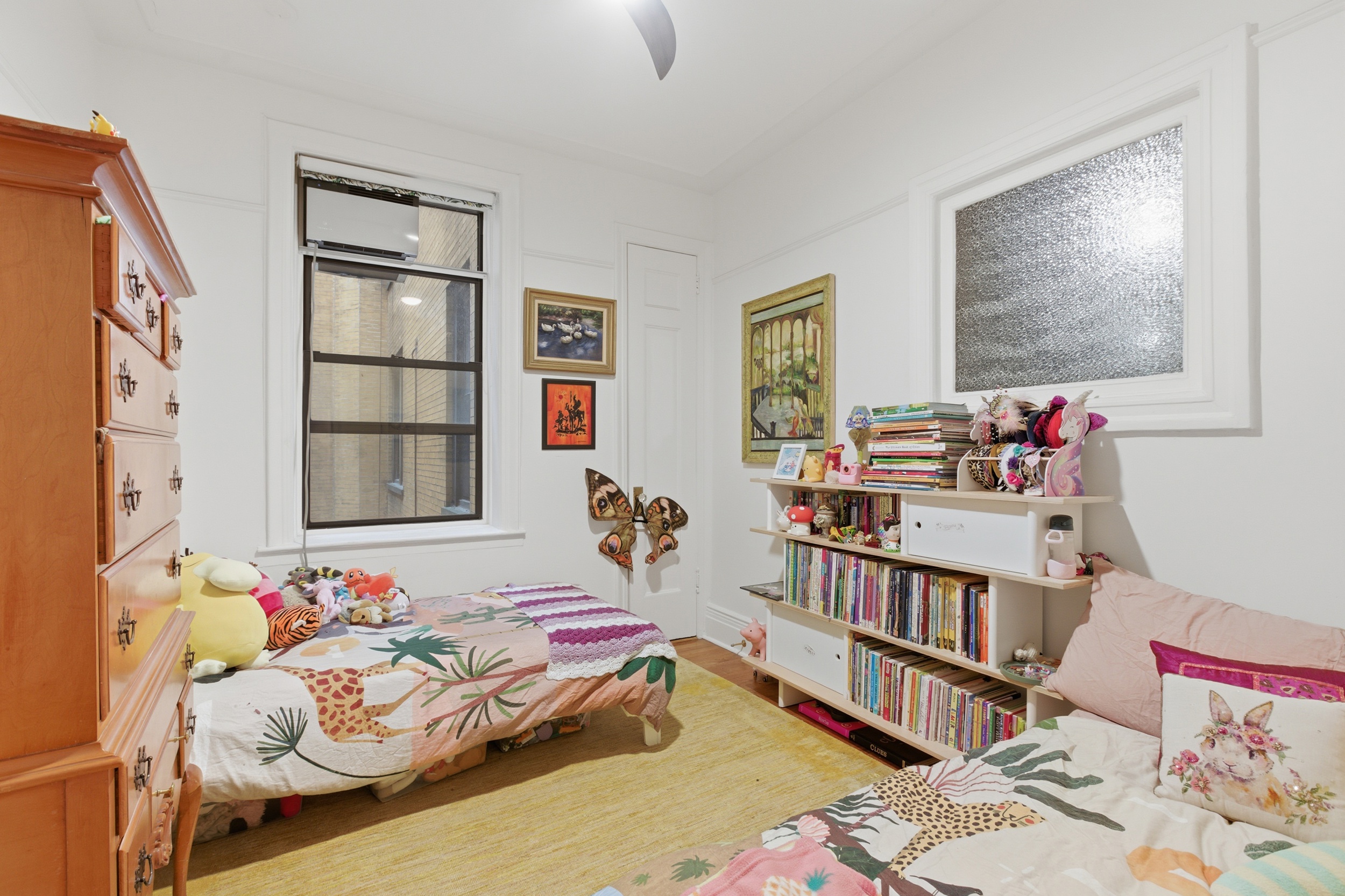 532 West 111th Street, Unit 26 Manhattan, NY 10025 - Photo 11 of 14 a bedroom with a bed and a book shelf