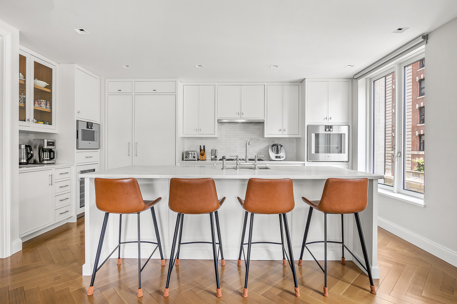 250 West 81st Street, Unit 4A Manhattan, NY 10024 - Photo 5 of 26 a kitchen with stainless steel appliances granite countertop a table chairs and a refrigerator