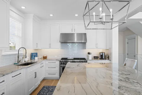 a kitchen with stainless steel appliances granite countertop a sink a stove and cabinets
