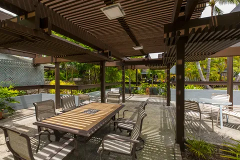 a view of a patio with table and chairs and wooden floor next to a yard
