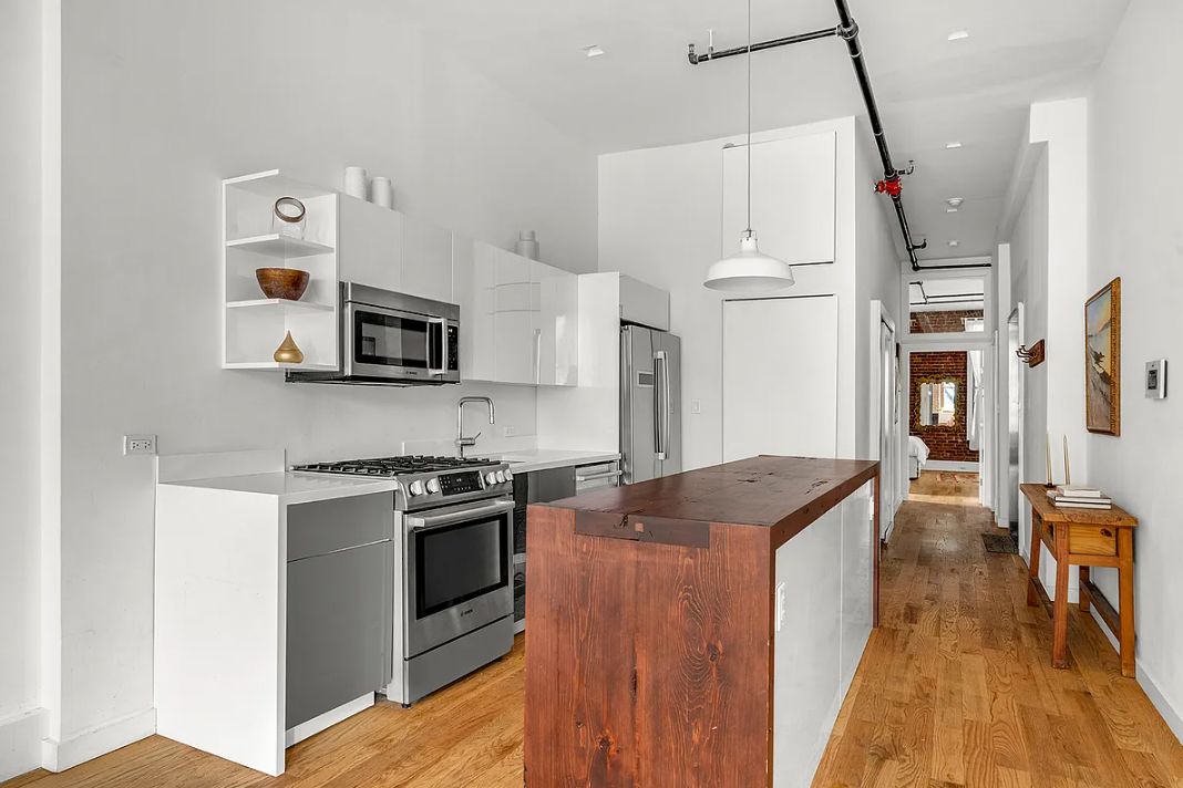 293 Church Street, Unit 5 Manhattan, NY 10013 - Photo 3 of 8 a kitchen with stainless steel appliances granite countertop a stove a sink and a refrigerator