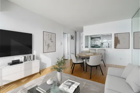a view of a big room with wooden floor and windows