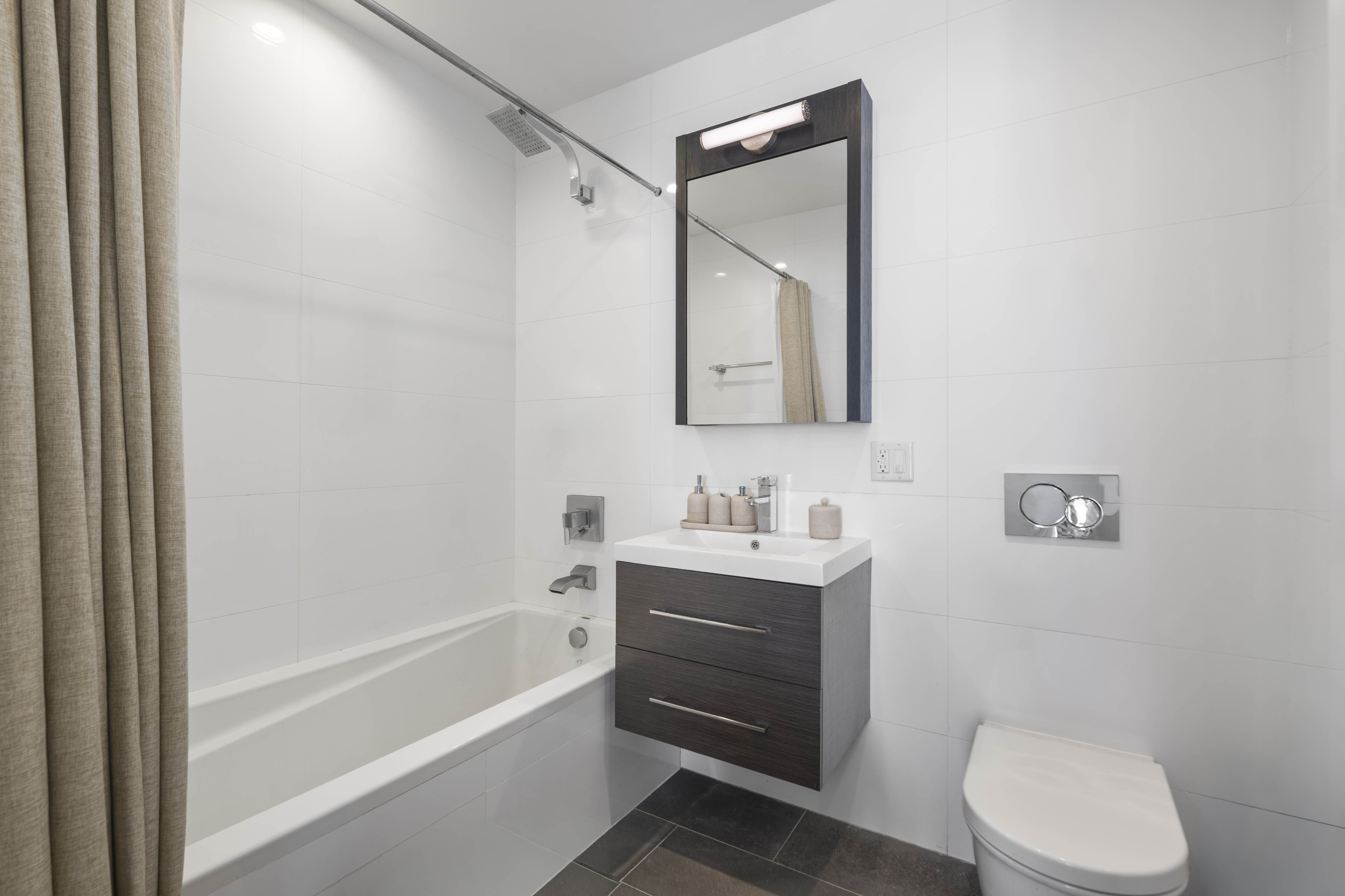695 6th Avenue, Unit 2P Brooklyn, NY 11215 - Photo 8 of 15 a bathroom with a toilet a sink a mirror a bathtub and vanity