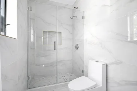 a bathroom with a toilet and a shower