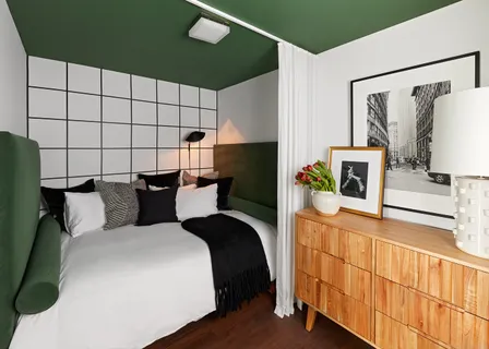 a bed room with a bed and a flat tv screen on a dresser