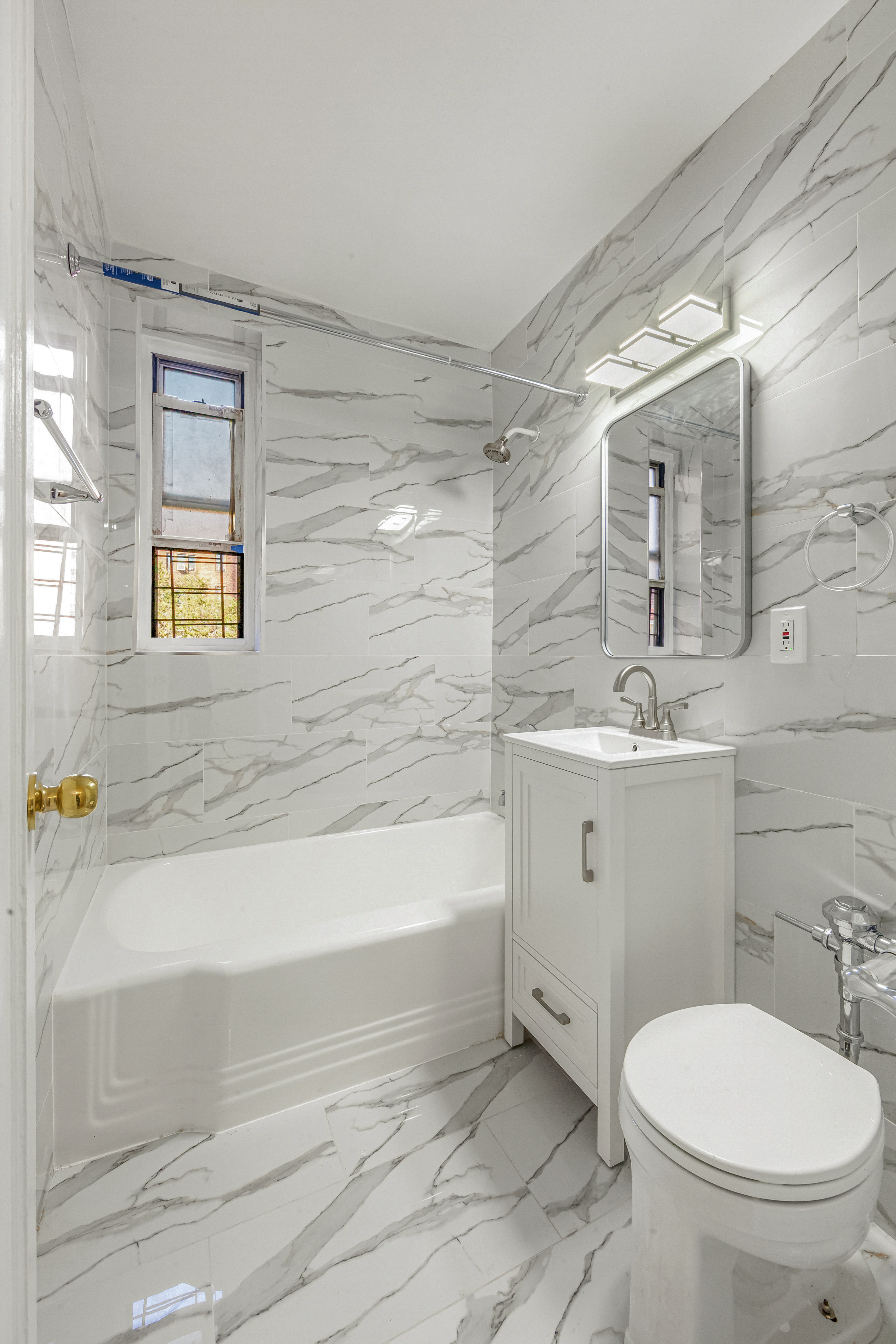 76-10 34th Avenue, Unit 2H Queens, NY 11372 - Photo 7 of 12 a bathroom with a sink a toilet and bathtub