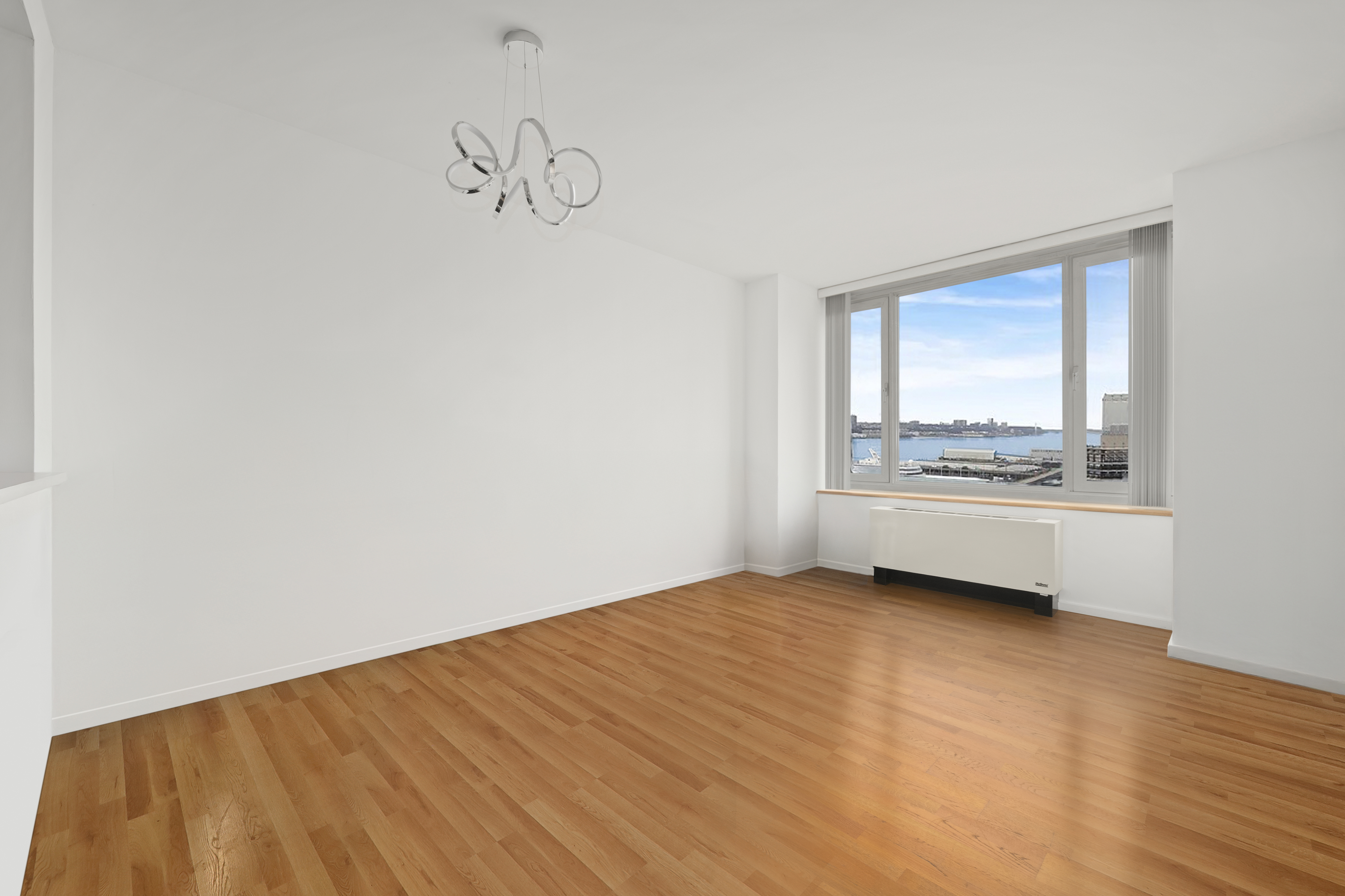 635 West 42nd Street, Unit 12D Manhattan, NY 10036 - Photo 2 of 18 a view of an empty room with a window and wooden floor