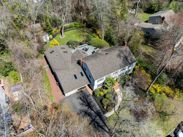 an aerial view of a houses with a lush green hillside