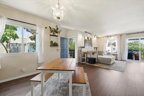 a living room with furniture large window and wooden floor