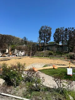 a view of swimming pool with outdoor seating and trees in the background