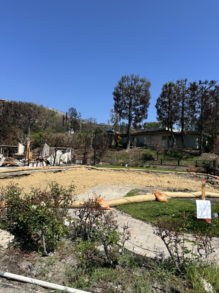 a view of swimming pool with outdoor seating and trees in the background