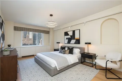 a bedroom with a large bed and windows