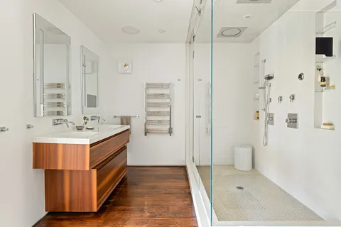 a bathroom with a double vanity sink mirror and shower