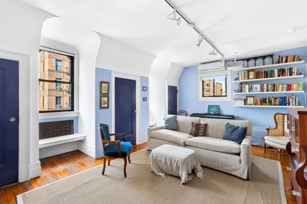 a living room with furniture and a book shelf