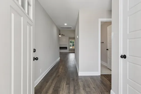 a view of a hallway with wooden floor