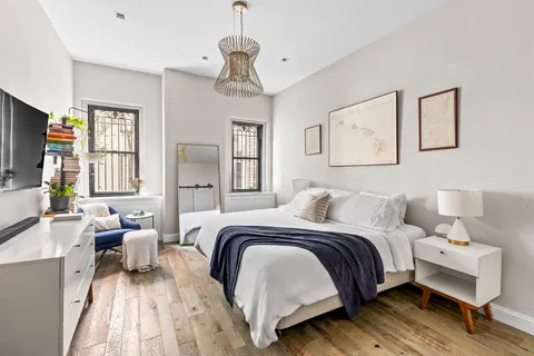 a bedroom with a bed couches and a flat tv screen
