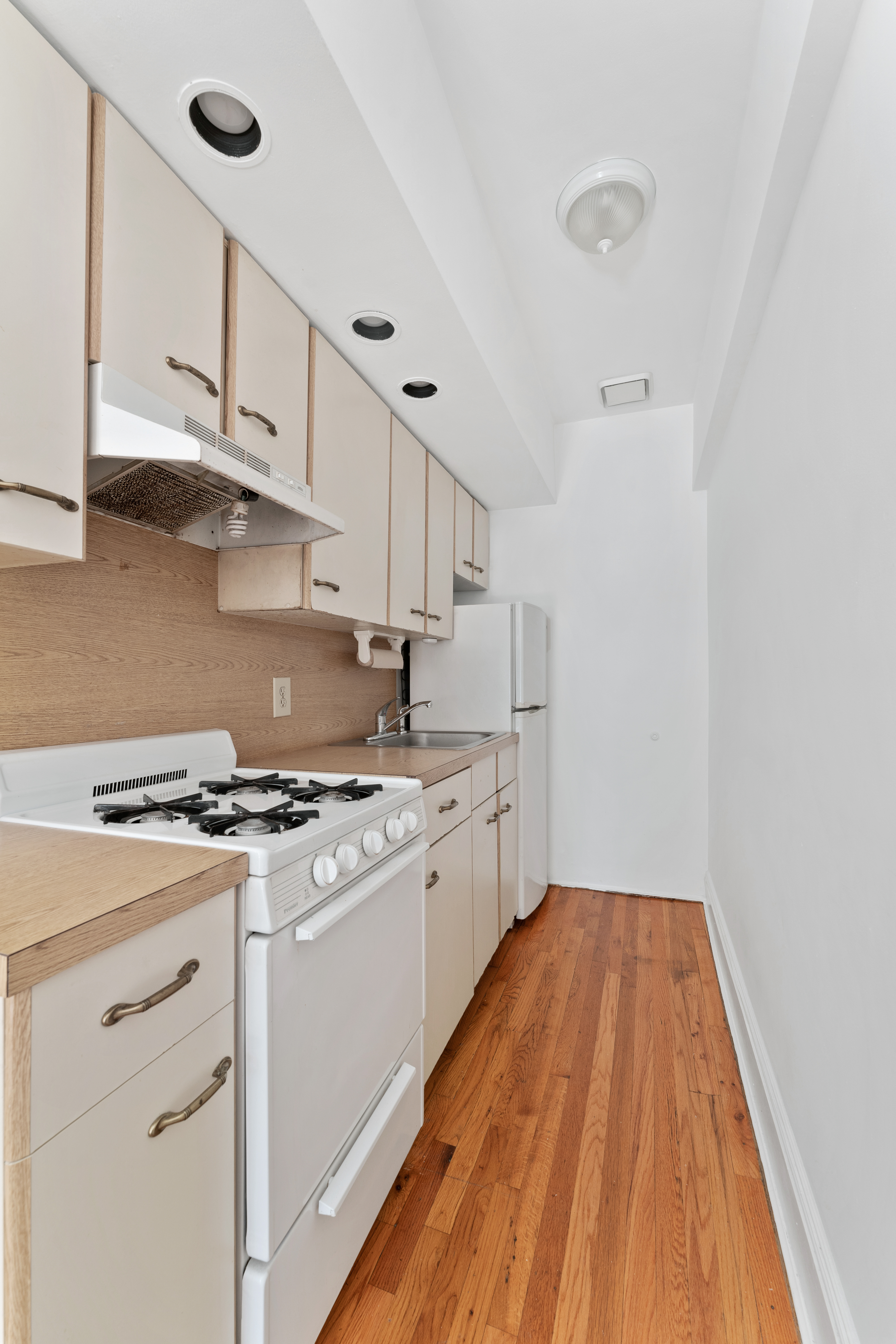 353 12th Street, Unit 10 Brooklyn, NY 11215 - Photo 4 of 10 a kitchen with white cabinets appliances and wooden floor