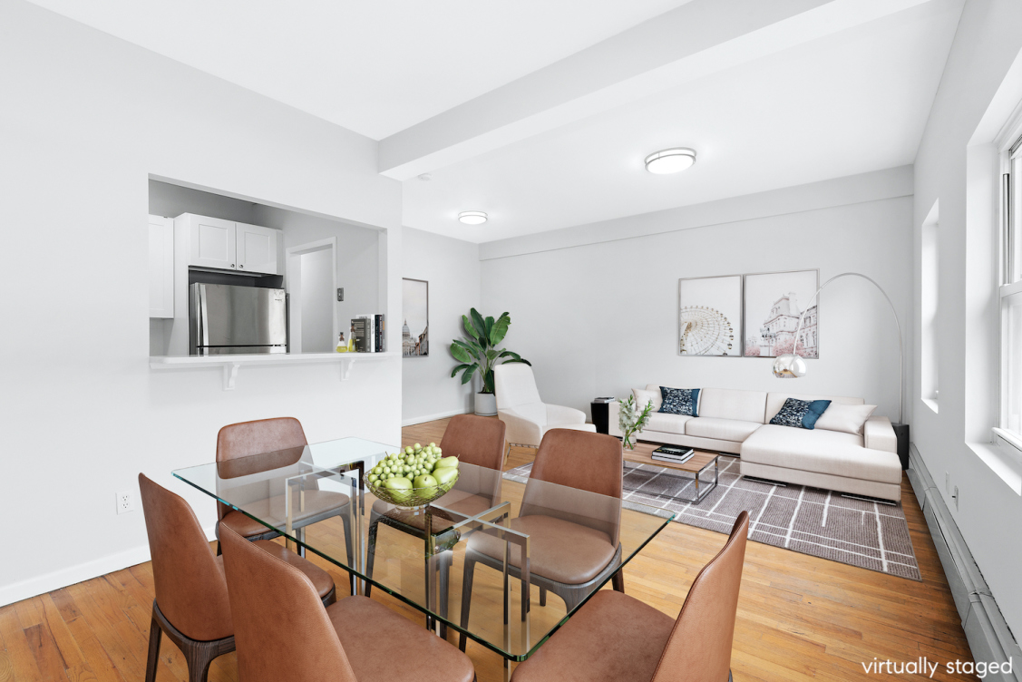 a living room with furniture potted plant and kitchen view