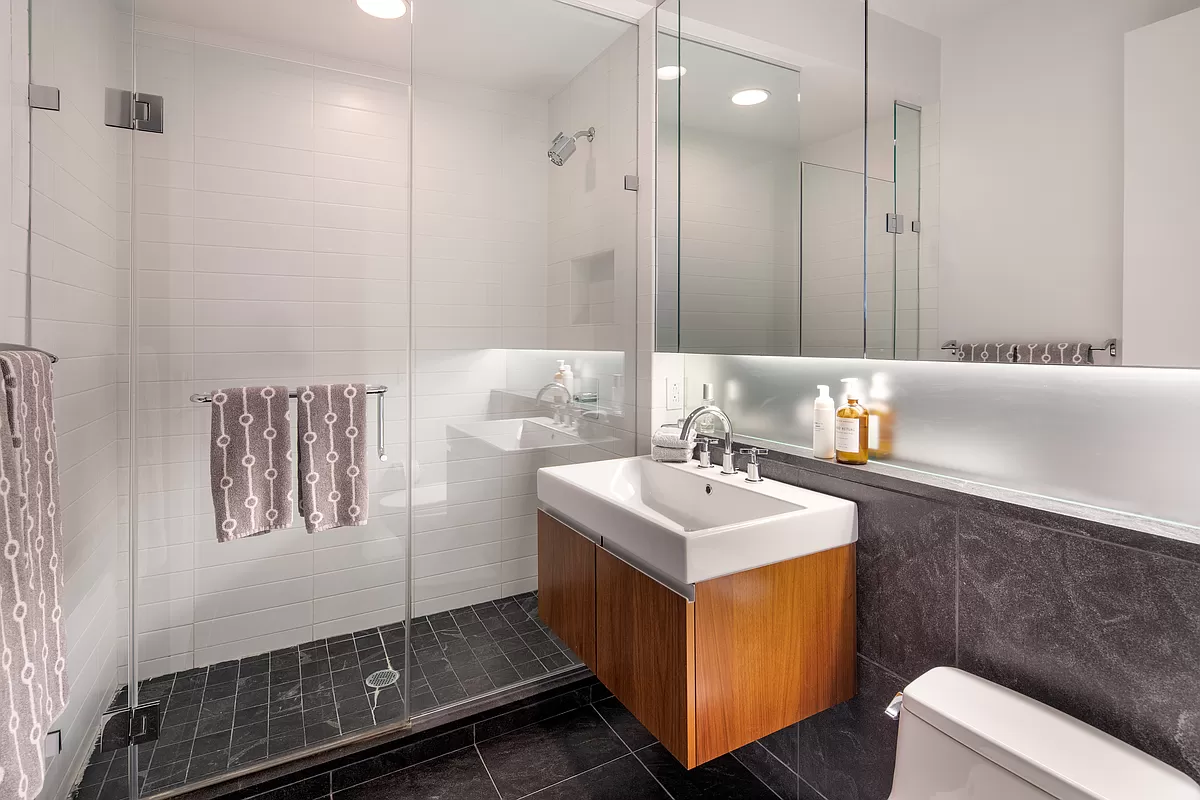 311 West Broadway, Unit 6J Manhattan, NY 10013 - Photo 13 of 19 a bathroom with a sink a mirror and a shower
