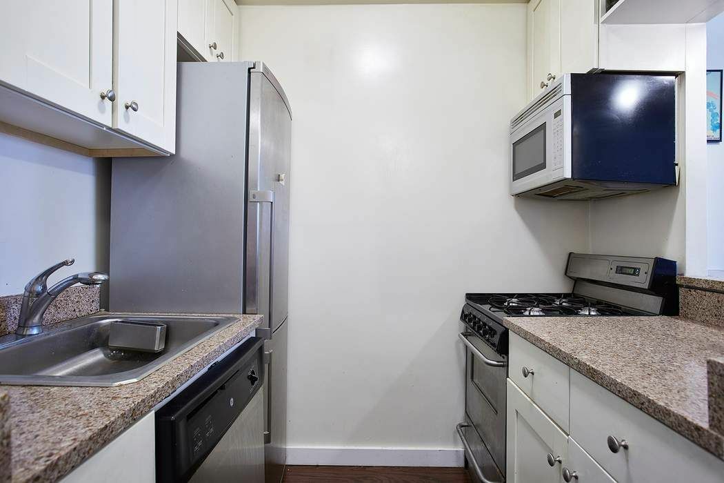 111 3rd Avenue, Unit PHK Manhattan, NY 10003 - Photo 2 of 11 a kitchen with stainless steel appliances granite countertop a sink stove and refrigerator